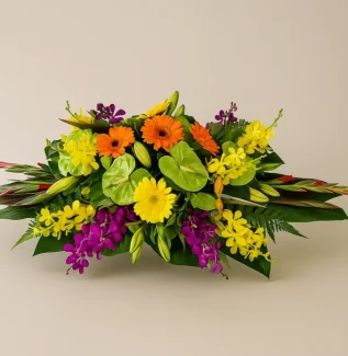 Flower centrepiece Gold Coast with bright colourful seasonal flowers in a low table arrangement