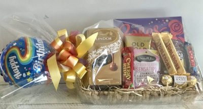 Chocolate gift basket with helium balloon, beautifully arranged for delivery with assorted chocolates and decorative packaging