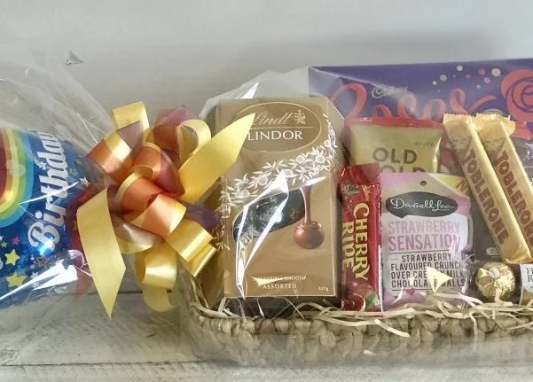 Chocolate gift basket with helium balloon, beautifully arranged for delivery with assorted chocolates and decorative packaging