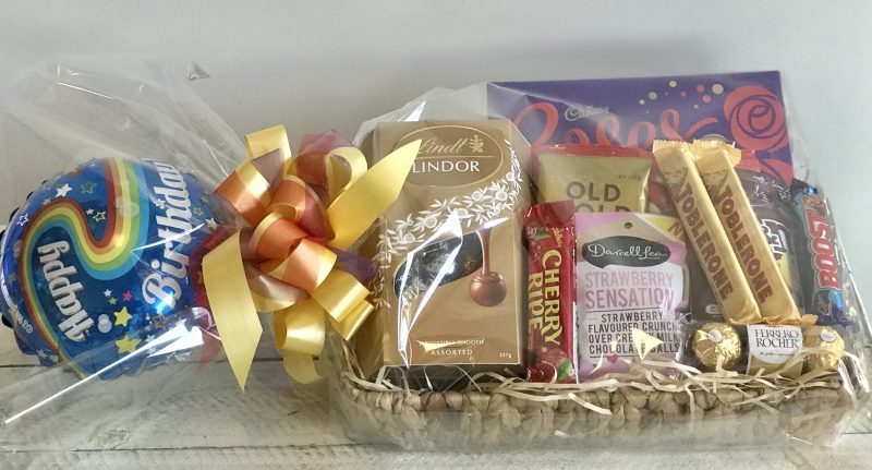Chocolate gift basket with helium balloon, beautifully arranged for delivery with assorted chocolates and decorative packaging