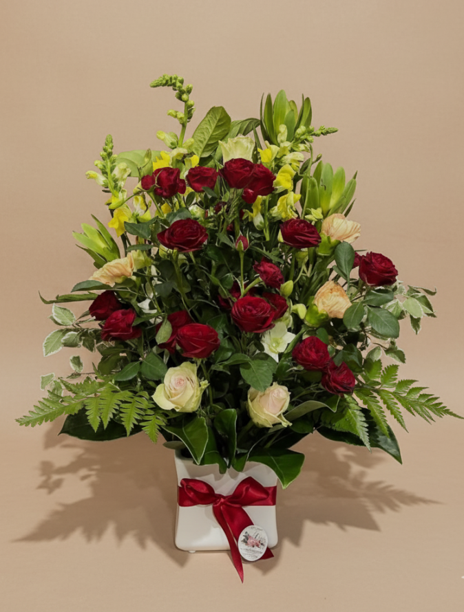 Red rose arrangement with lilies, cream roses and lush green foliage in a ceramic pot – Flowers of Southport
