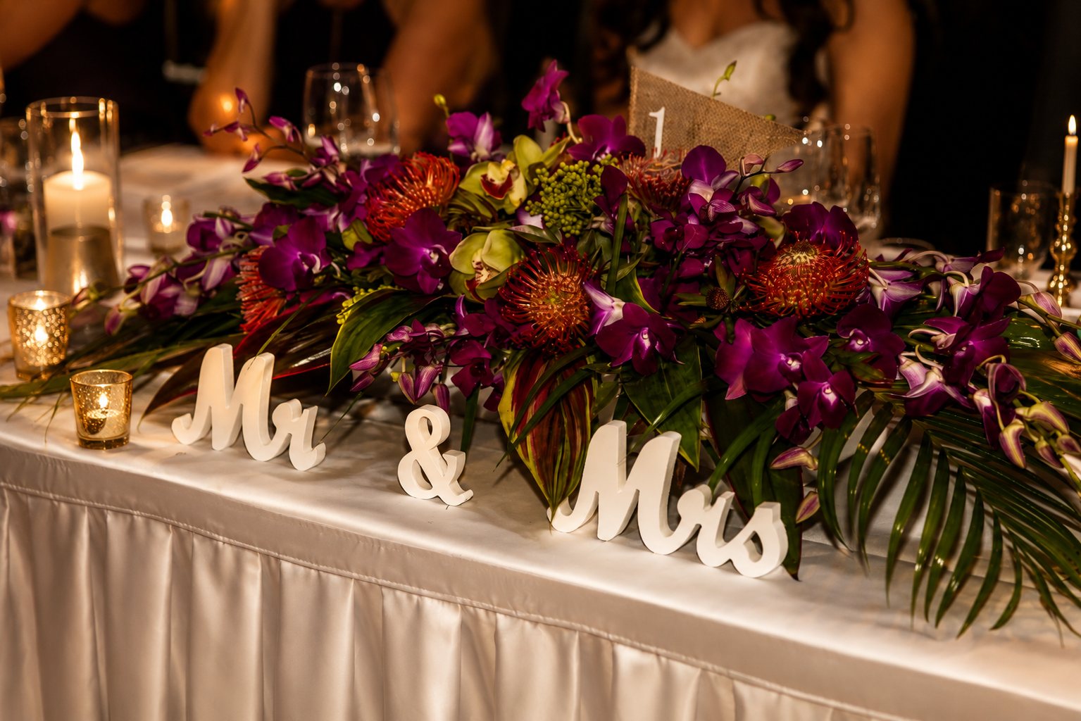 Sweetheart table floral centrepiece with orchids, proteas and palms — Mount Tamborine wedding
