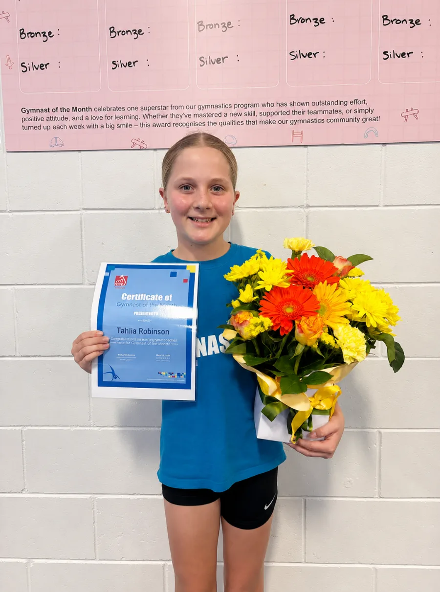 Tahlia, PCYC Ashmore May Gymnast of the Month, holding her certificate and the Flowers of Southport bouquet she received.