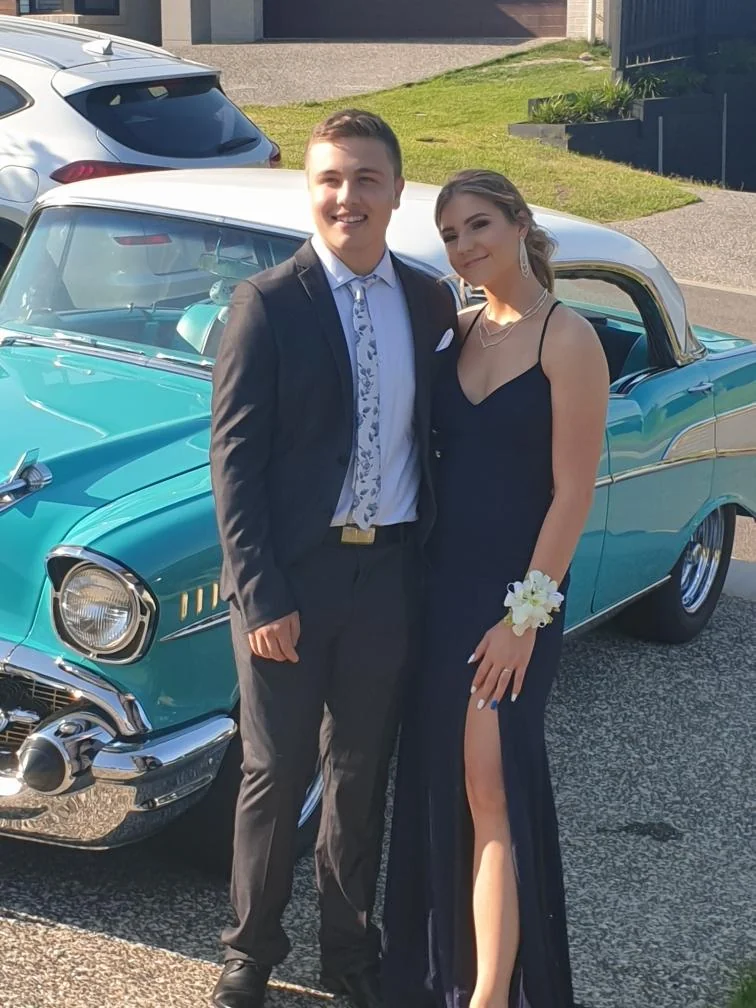 Gold Coast school formal couple with a white wrist corsage worn with a navy dress